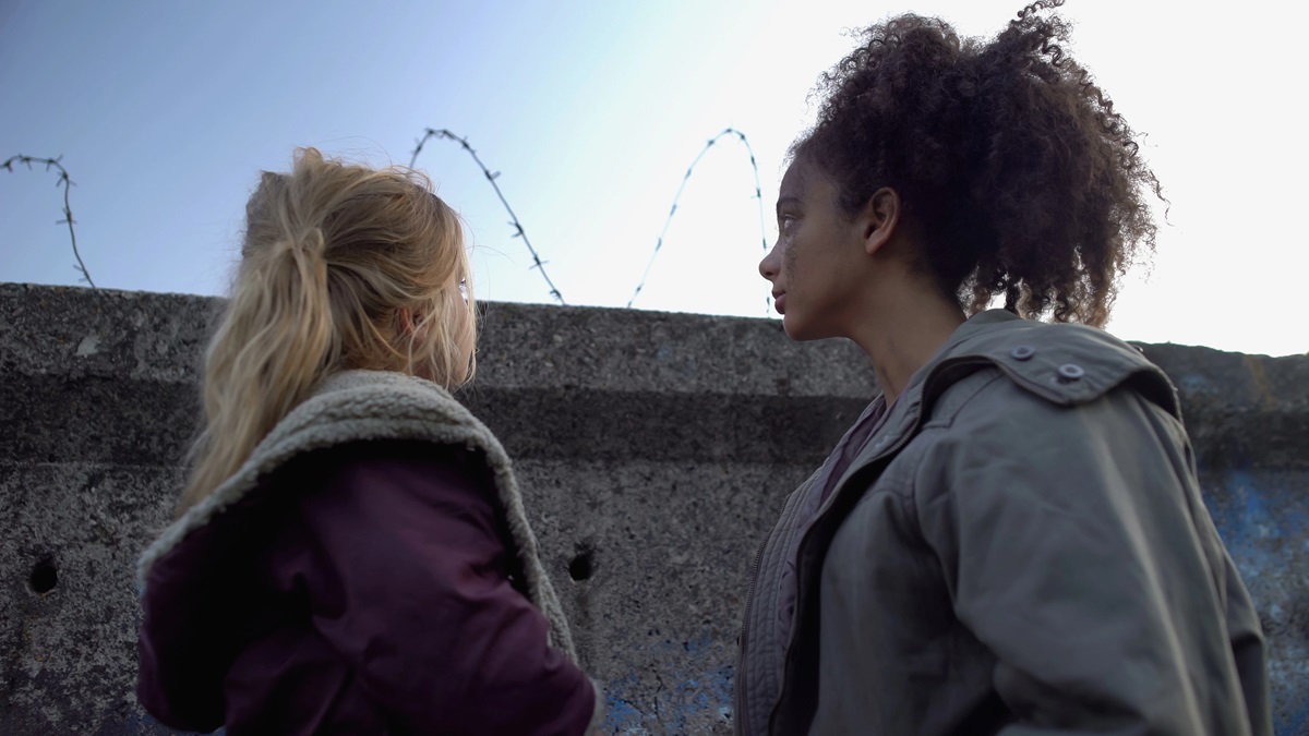 Girls standing in front of prison wall