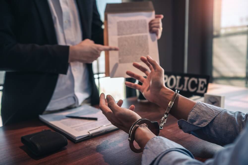 Man in handcuffs and police reading his rights